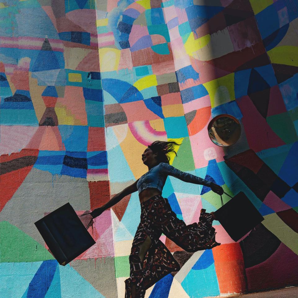 Beeld dame met winkeltassen kleurrijke mural